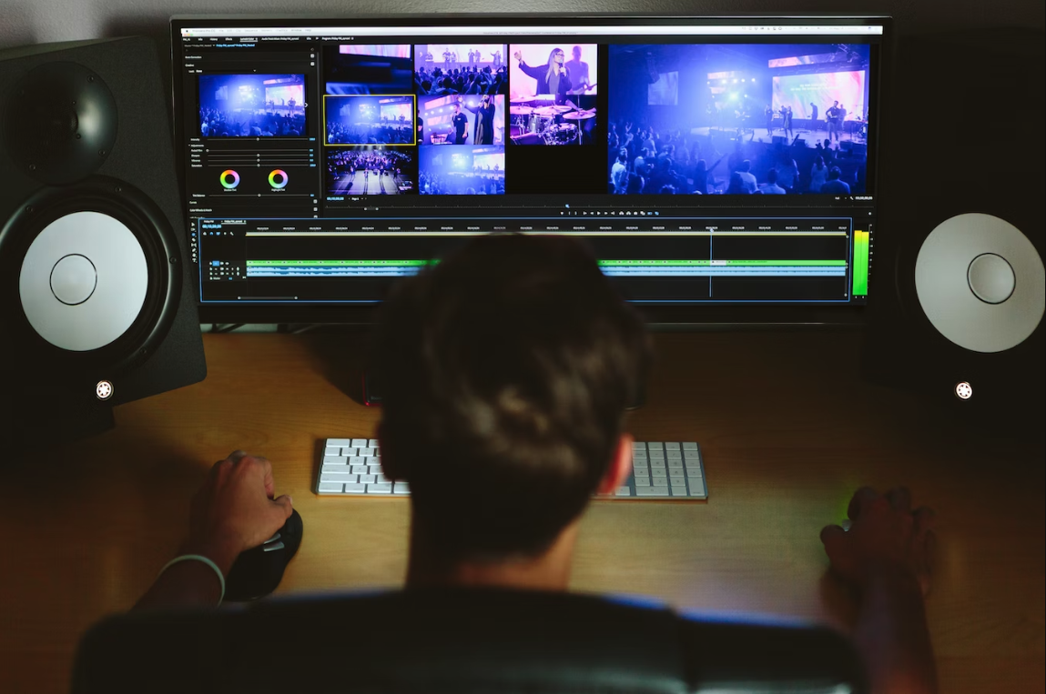 an editor using editing software on multiple monitors to edit a music event