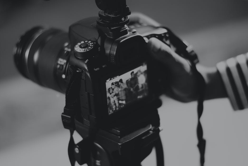 black and white picture of a hand operating a dslr camera