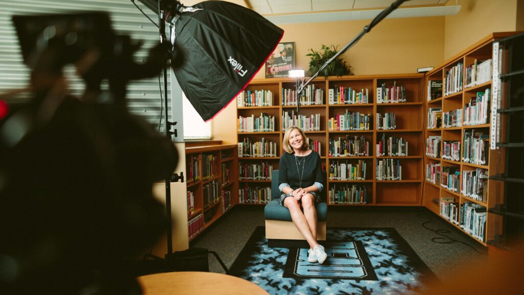 Woman in a room being filmed for a corporate video