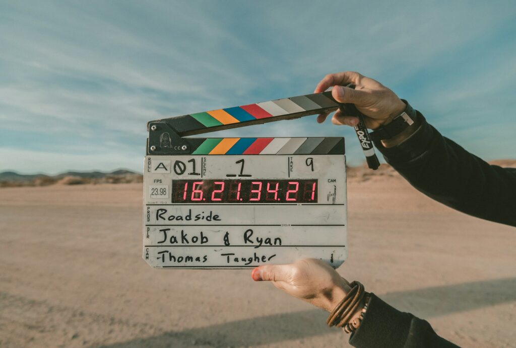 Person holding a clapperboard at an outdoor location