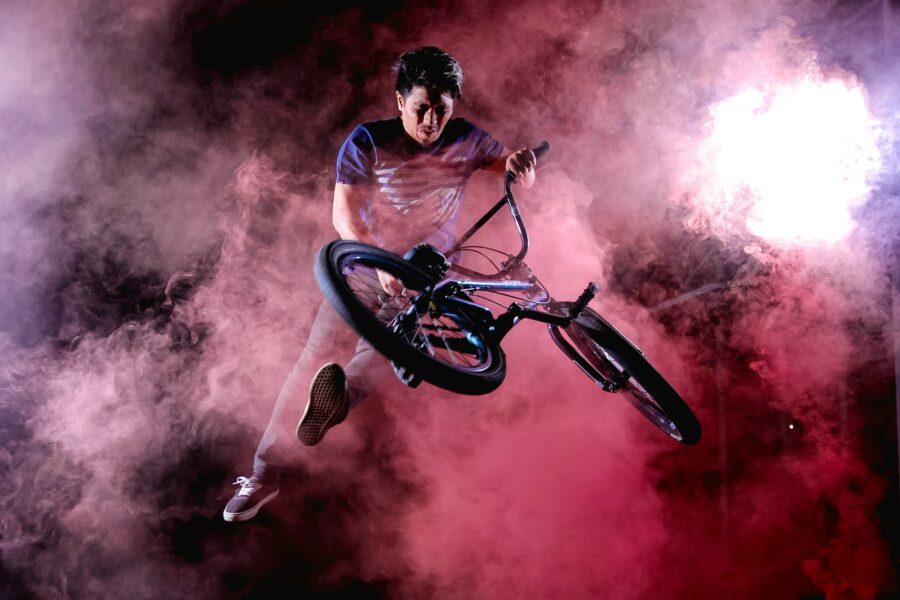 Man doing a bicycle stunt surrounded by fog