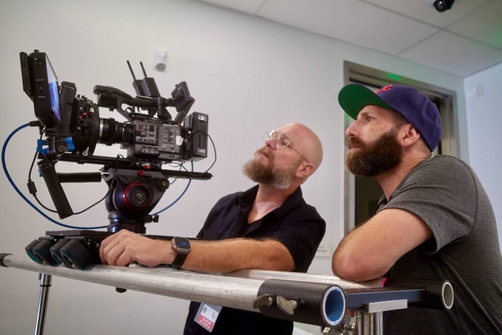 Behind-the-scenes video production with professional camera operators reviewing footage for a corporate shoot in Orange County