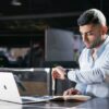 Business professional checking the time while browsing on a laptop