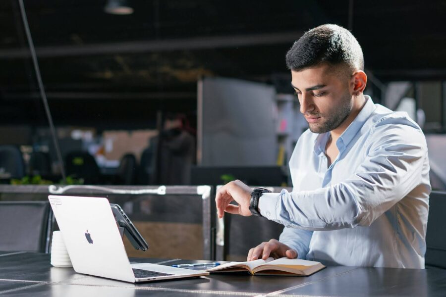 Business professional checking the time while browsing on a laptop